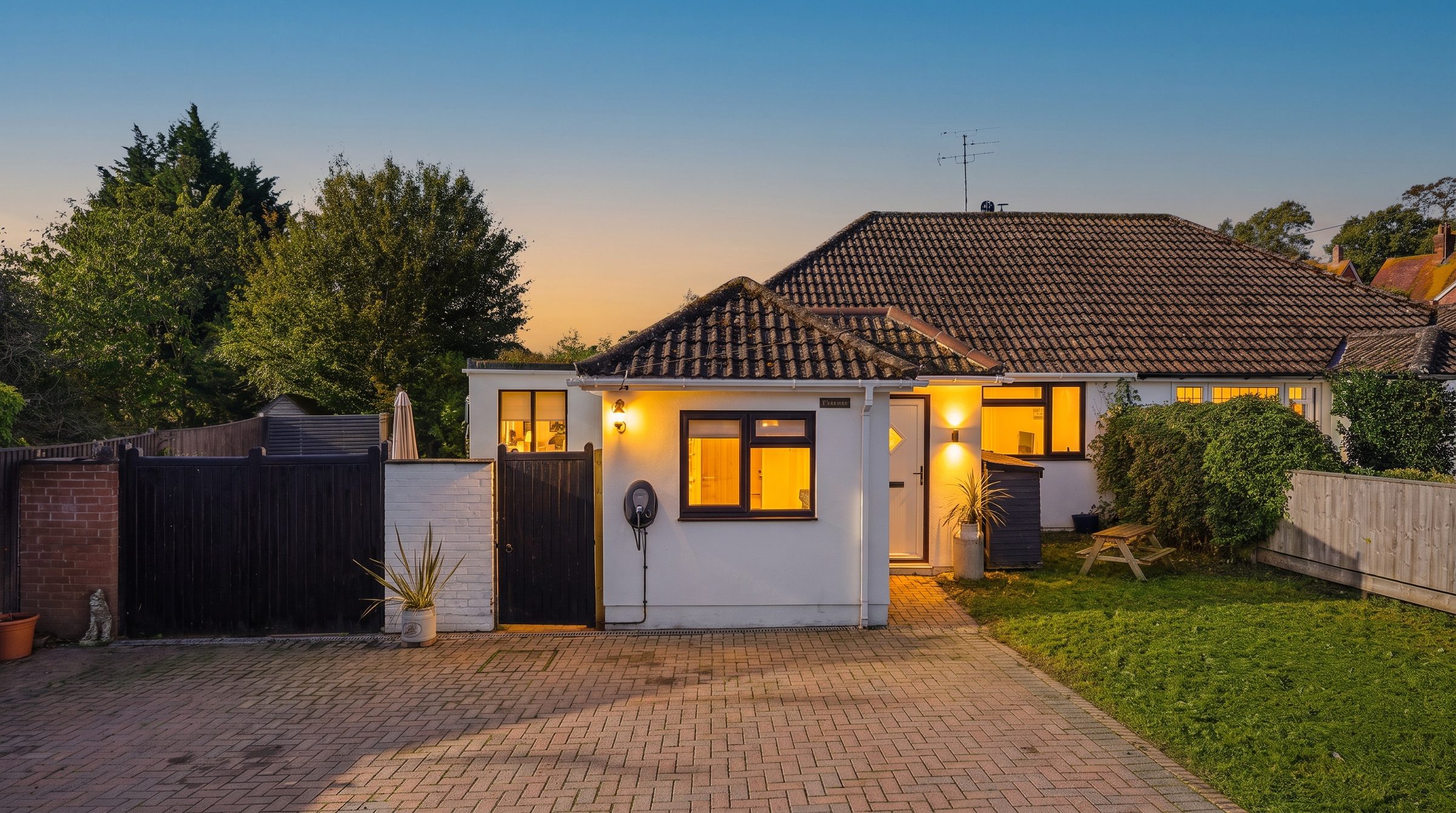 Petrona at dusk from the driveway, lights on inside